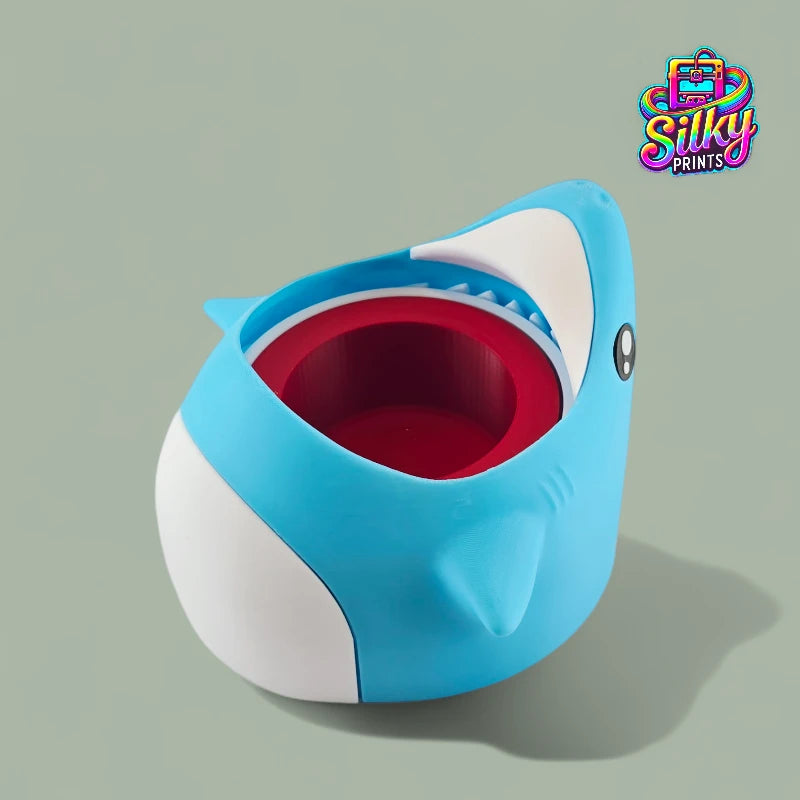Blue shark-shaped container with a red interior on a gray background, featuring the Silky Prints logo.