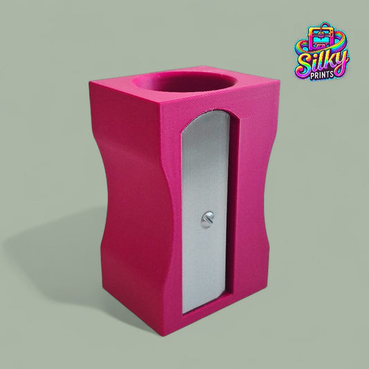 Purple pencil sharpener with a silver blade on a gray background, branded 'Silky Prints'.